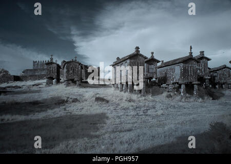 Lindoso Granit mais Getreidespeicher und der mittelalterlichen Burg, Dorf von Peneda Geres National Park, Northern Portugal. Ir-Filter verwendet. Stockfoto