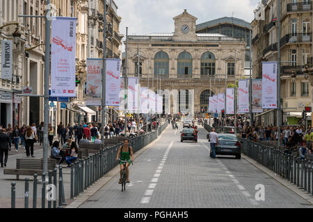 Lille, Frankreich - 15. Juni 2018: Verkehr und Menschen zu Fuß auf Faidherbe Straße. Lille Bahnhof im Hintergrund. Stockfoto