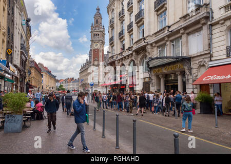 Lille, Frankreich - 15. Juni 2018: die Menschen zu Fuß auf Pierre Mauroy Straße. Glockenturm der Chambre de Commerce im Hintergrund. Stockfoto