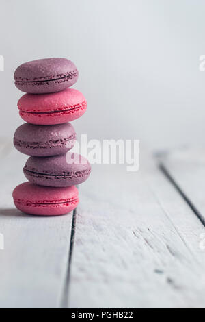 Gruppe der Macarons aus Erdbeeren, Sahne, Schokolade und Heidelbeeren. Rustikale Foto. Makro. Stockfoto