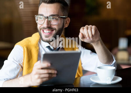 Portrait von lächelnden Geschäftsmann mit digitalen tablet, während an der Theke im Cafe sitzen und weg schauen nachdenklich Stockfoto