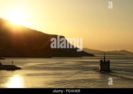 Griechenland, Kalymnos, Dodekanes, Europa.. Am frühen Morgen mit der Fähre aus dem Hafen auf dem ruhigen Meer. Die Sonne malt der Himmel einem weichen Pastelltönen Stockfoto