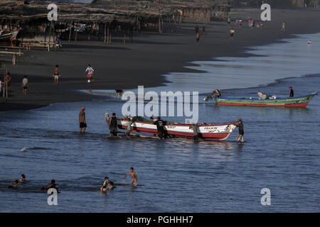 Fischer push Holzboot bis Sandstrand von Playa El Cuco, El Salvador Stockfoto