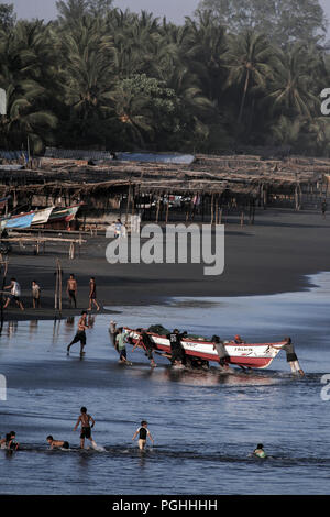 Fischer push Holzboot bis Sandstrand von Playa El Cuco, El Salvador Stockfoto