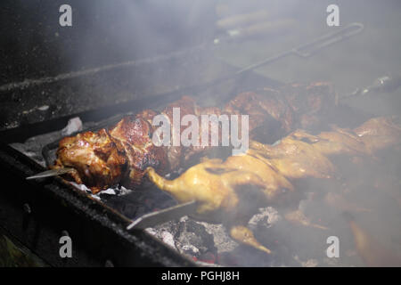 Schweinefleisch und Wachteln Grill am Spieß braten auf einem Grill Brazier Stockfoto