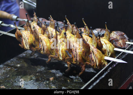 Schweinefleisch und Wachteln Grill am Spieß braten auf einem Grill Brazier Stockfoto