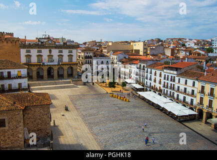 Luftaufnahme von Plaza Mayor in Caceres während eines schönen und sonnigen Tag. Rathaus anzeigen. Monumentale Mauern umgebenen Platz voll von alten Gebäuden und Personen. Stockfoto