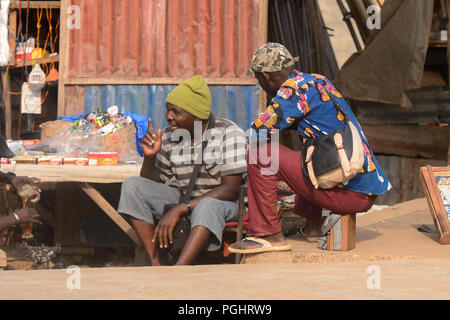 OUIDAH, BENIN - Jan 10, 2017: Unbekannter beninischen Männer sitzen auf der Straße. Benin Menschen leiden unter der Armut wegen der schlechten Konjunktur Stockfoto