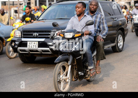 OUIDAH, BENIN - Jan 10, 2017: Unbekannter beninischen Mann reitet ein Motorrad. Benin Menschen leiden unter der Armut wegen der schlechten Konjunktur Stockfoto