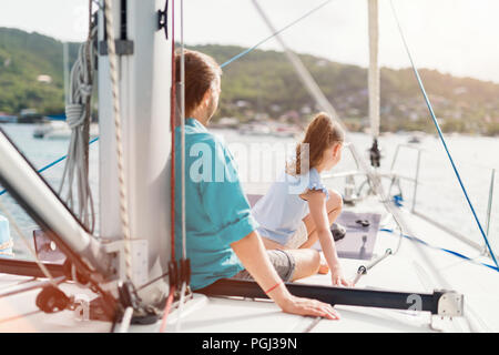 Familie von Vater und Tochter an Bord der Segelyacht Sonnenuntergang Stockfoto