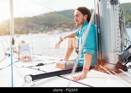 Familie von Vater und Tochter an Bord der Segelyacht Sonnenuntergang Stockfoto