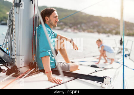 Familie von Vater und Tochter an Bord der Segelyacht Sonnenuntergang Stockfoto