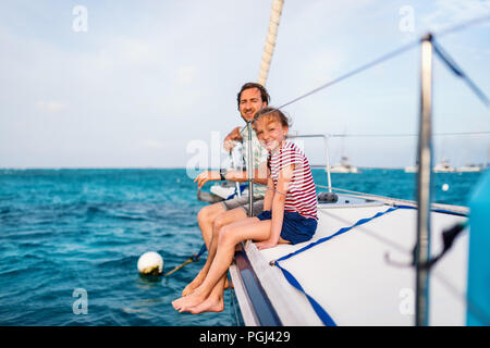 Vater und Tochter an Bord der Segelyacht Sonnenuntergang Stockfoto