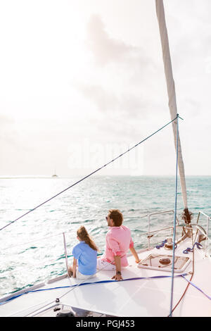 Vater und Tochter an Bord der Segelyacht Sonnenuntergang Stockfoto