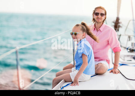 Familie von Vater und Tochter an Bord der Segelyacht Sonnenuntergang Stockfoto