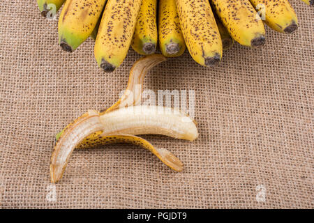 Bündel gelb sommersprossige Bananen auf einer Leinwand Textur Stockfoto