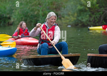 Shropshire, Großbritannien. 27. August 2018. Wettbewerber in den jährlichen August Bank Holiday Coracle Rennen auf dem Fluss Severn in Ironbridge in Shropshire. Diese kleinen handgebaut Fluss haben auf Flüssen in Großbritannien seit Hunderten von Jahren verwendet und die ironbridge Rassen haben für viele Jahre gehalten worden. Stockfoto