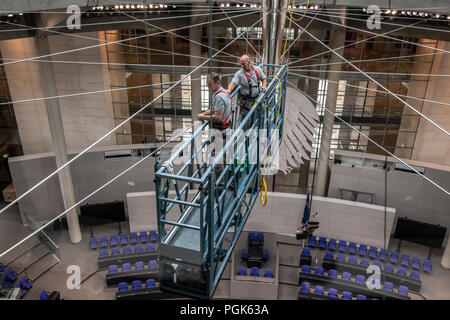 Berlin, Deutschland. 07 Aug, 2018. Arbeitnehmer stehen in einer Gondel im Parlament Halle der Reichstag. Von dort aus, sie reinigen die Glaskuppel Windows. Credit: Paul Zinken/dpa/Alamy leben Nachrichten Stockfoto