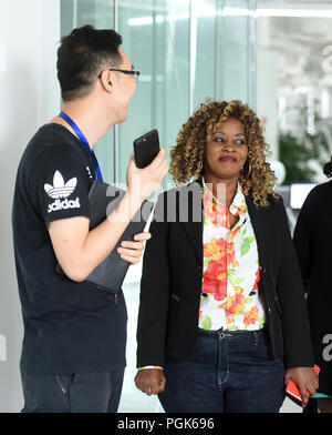 (180827) - Peking, 27.08.2007 2018 (Xinhua) - hilda Malecela (R) Gespräche mit ein Kollege an StarTimes Gruppe in Peking, der Hauptstadt von China, Nov. 14, 2018. Malecela kommt aus einer ländlichen Familie von Tansania. Sie ist eine dubber der Chinesischen Medien Firma StarTimes. Im Jahr 2016 gewann sie eine Synchronisation Contest in Tansania und eine Gelegenheit erhielt in der Zentrale der StarTimes zu arbeiten. Malecela sah einen Film mit Jackie Chan in der Hochschule und wollte in der Film- und Fernsehbranche tätig zu sein. Nach dem Abitur wurde sie dubber. Die Swahili - betitelte im chinesischen Fernsehen Dramen in Tansania ein Kanal für Malecela bereitgestellt Stockfoto