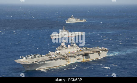 Philippinischen Meer. 25 Aug, 2018. Philippinischen MEER (Aug. 26, 2018) Das amphibisches Schiff USS Wasp (LHD1) und die amphibische Landung dock Schiff USS Ashland (LSD 48), die beide einen Teil der Wasp Amphibious Ready Group (ARG), sind im Gange, neben der Japan Maritime Verteidigung-kraft (JMSDF) amphibious Transport dock Schiff JS Osumi (LST 4001) Während einer Übung vorbei (PASSEX) im philippinischen Meer, Aug 26., 2018. PASSEX aktiviert die Wasp ARG und die JMSDF eine Chance Kommunikation und rangieren Verfahren zu üben. Die Wespe ARG ist derzeit in der Region zur Verbesserung der Interoperabilität Stockfoto