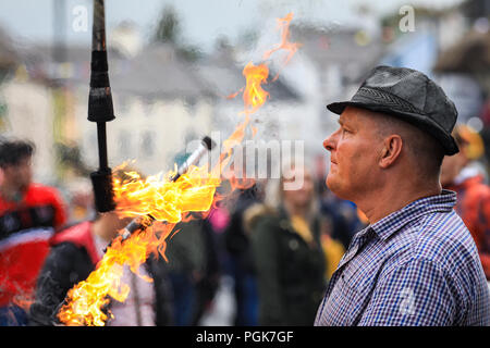 Ballycastle, Nordirland. Montag, 27 August, 2018. Eine street Entertainer jongliert mit Fackeln an der Ould Lammas Fair in Ballycastle Die Ould Lammas Fair ist die älteste Messe in Irland. Das Wort Lammas kommt von 'Laib Masse" - traditionell Gebackenes Brot aus der ersten Körner von Herbst wurden auf die Kirche verändern. Während eines Bezugszeitraums des 17. Jahrhunderts, haben die Händler auf der Messe strömten zu kaufen und Tiere verkaufen, eine Tradition, die Kreditkarte weiter: Graham Service/Alamy leben Nachrichten Stockfoto