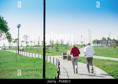 Rückansicht Portrait von Active Senior Paar zusammen im Park läuft, Kopie Raum Stockfoto
