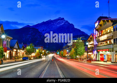 Blick auf die Straße von berühmten Banff Avenue in der Dämmerung. Banff ist ein Ferienort und eines der beliebtesten Reiseziele in Kanada. Stockfoto
