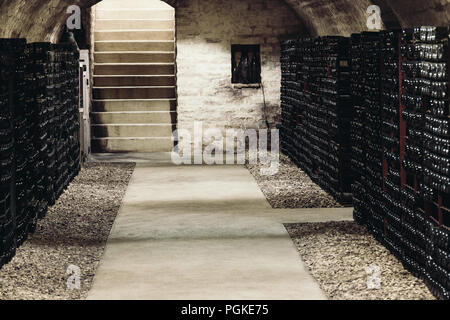 Alter Weinkeller, an den Wänden sind Regale mit viele Flaschen Wein. Stockfoto