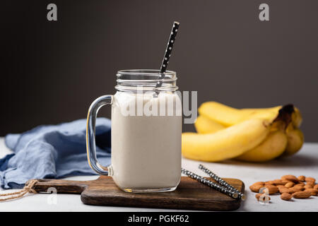 Banane protein Smoothie oder Milchshake in Trinkglas über dunkelgrauer Hintergrund, kopieren Platz für Text Stockfoto