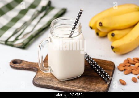 Banane protein Smoothie oder Milchshake in Glas auf Holz serviert. Detailansicht, selektiver Fokus Stockfoto