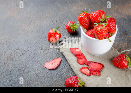 Reife Saftige Erdbeeren in Form von trockenen Späne und Obst Leder rollt auf dunklem Hintergrund. Detox Konzept. Gesunde Lebensmittel, Obst erstaunliche Süßigkeit. Stockfoto