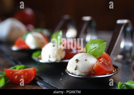 Vorspeisen mit Mozzarella und Tomaten auf Löffel - selektive Fokus Stockfoto