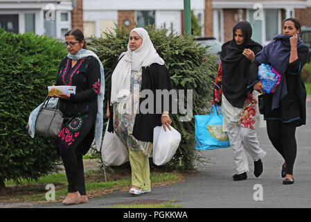 Menschen mit Nahrung zu einer Eigenschaft auf northdown Straße in Solihull, wo einer Morduntersuchung, nachdem eine Mutter und eine Tochter 49 und 22 Jahren lanciert wurden erstochen. Stockfoto