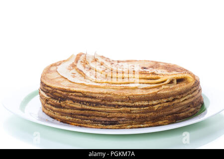 Große hohe dünne Pfannkuchen in einer Platte auf einem weißen Hintergrund Stapel Stockfoto