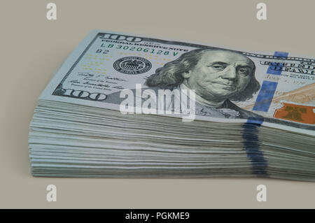 Teil des Satzes mit einer Verschiebung von 10 tausend Dollar in den Rechnungen von einhundert Dollar. Auf grauem Hintergrund. Anzeigen in einem Winkel. Stockfoto
