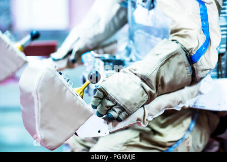 Ein Astronaut und Kosmonaut führen Sie arbeiten auf einer Raumstation mit Manipulator während deap Raum. Stockfoto