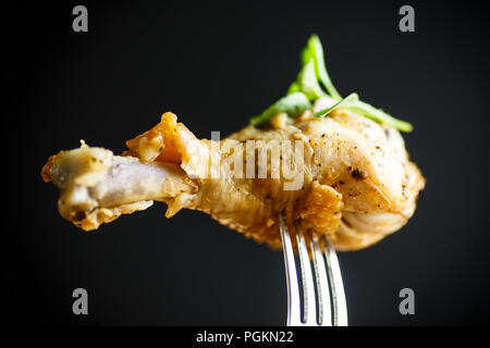 Fried Chicken Bein auf eine Gabel auf einem schwarzen Hintergrund Stockfoto