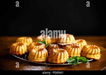 Süße Muffins Quark in Zucker Puder auf dem Holztisch Stockfoto