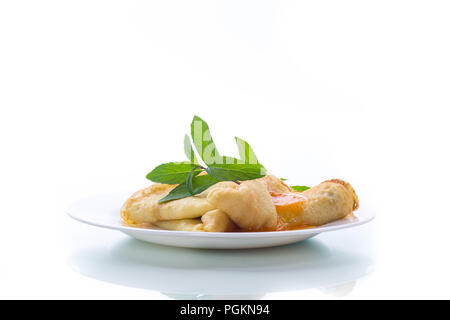 Süße dünne Pfannkuchen mit Marmelade in eine Platte auf weißem Hintergrund Stockfoto