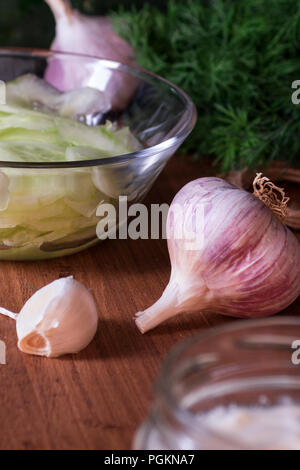 Lebensmittelzutaten Gurkensalat mit Joghurt oder Sauerrahm dressing zu machen. Pflanzliche Inhaltsstoffe in Lebensmitteln, Gurke, Knoblauch, Dill, Joghurt auf dem Tisch Stockfoto