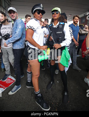 Partygänger verkleiden sich als Polizeibeamte an der Notting Hill Carnival in London. Stockfoto