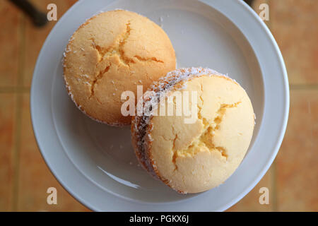 Ansicht von oben ein paar Alfajores, traditionelle lateinamerikanische Spezialitäten serviert auf Glas Tisch Stockfoto
