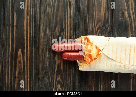 Ausschreibung Wurst in pita Brot auf hölzernen Hintergrund. Foto mit Kopie Raum Stockfoto