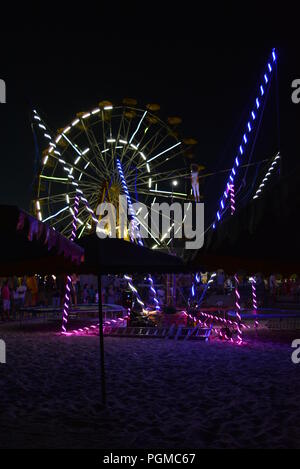 Am Strand des Schwarzen Meeres mit Kinderbecken, Trampolin mit Diodenbändern und Sonnenschirmen entlang der Küste. Stockfoto