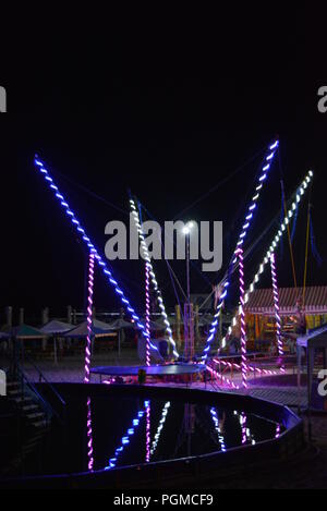 Am Strand des Schwarzen Meeres mit Kinderbecken, Trampolin mit Diodenbändern und Sonnenschirmen entlang der Küste. Stockfoto