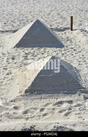 Am Strand am Schwarzen Meer wurden tagsüber zwei Pyramiden aus weißem Sand und Muscheln gebaut. Stockfoto