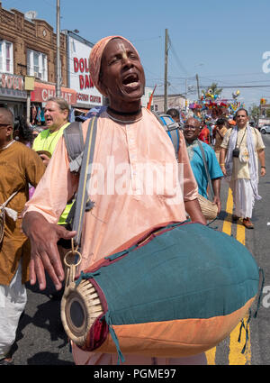 Ein Jamaikanischer hinduistischen Mann spielen Der mrdanga Indischen im Queens, New York Rathayatra Parade Trommel. Stockfoto