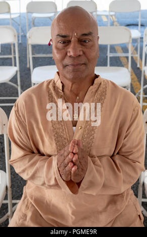 Eine indische amerikanische Pandit tragen eine Blume in sein Ohr und einen Davidstern um seinen Hals. In Queens, New York. Stockfoto