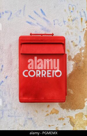 Bunt metallic mail box in roter Farbe an der Wand mit alter Lackierung in Lissabon. Mail Wort geschrieben. Stockfoto