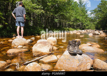 Pemigewasset Wildnis - Wanderer und Wanderschuhe trocknen weg am Felsen entlang der North Fork Ostniederlassung Pemigewasset River während der Sommermonate in L Stockfoto